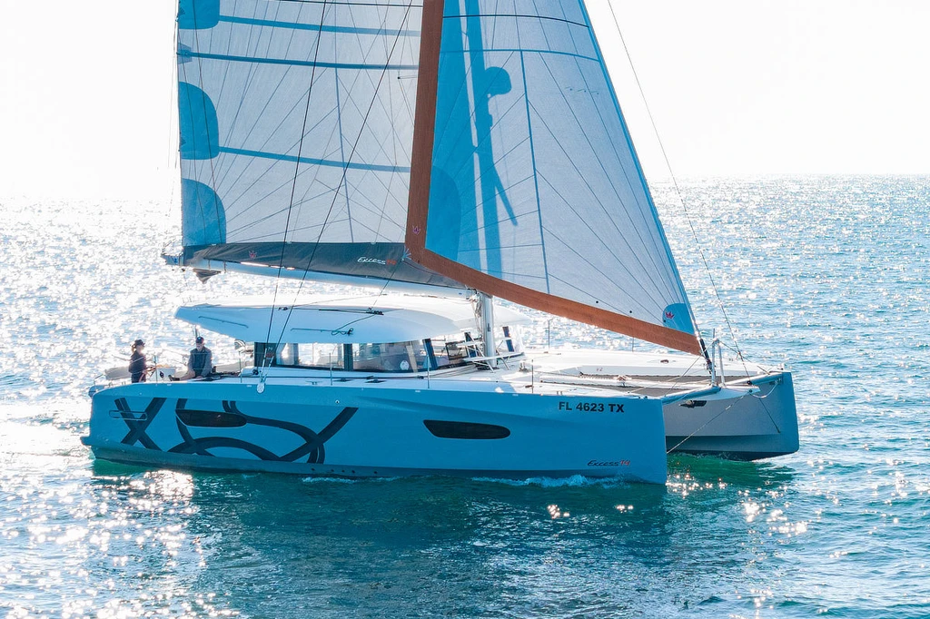 Private catamaran hosting a holiday party on the water at dusk on San Diego Bay with string lights